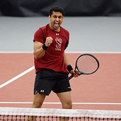 Rushil Patel fist pumps on tennis court after point