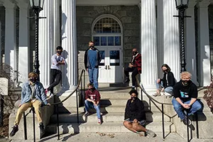 Students in mask wearing masks pose on stairs outside Parrish