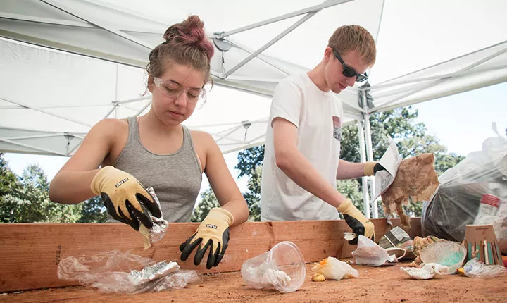 Students sort waste on a wooden table