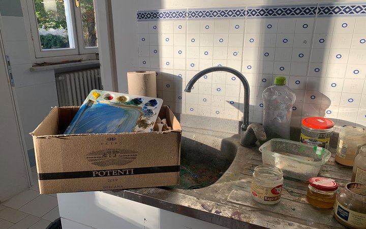 Box with paint-filled palette sticking out on sink