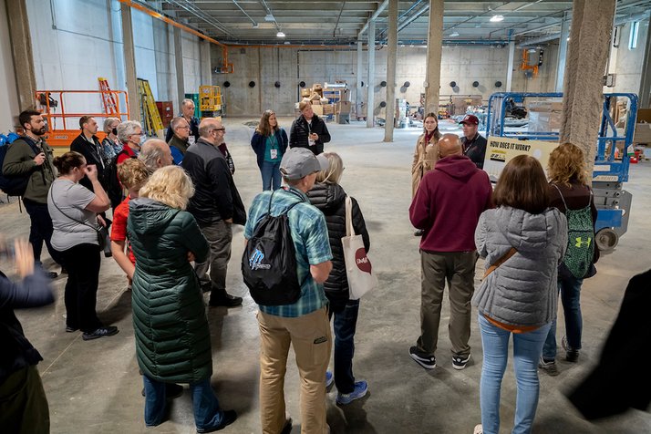 Group of people listen during tour of geoexchange plant