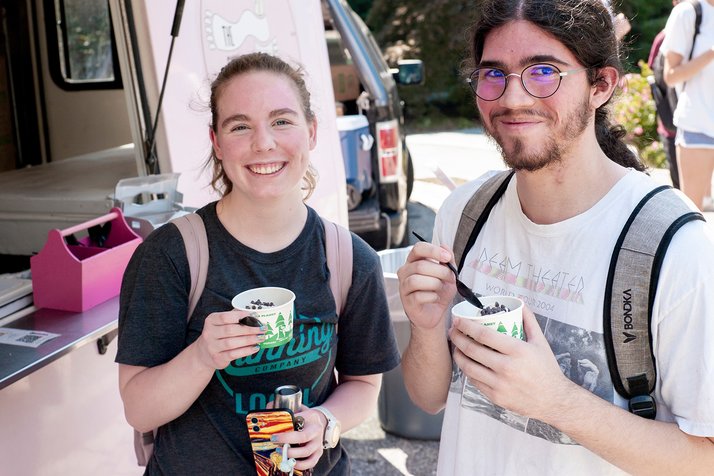 Two students hold cups of frozen treats