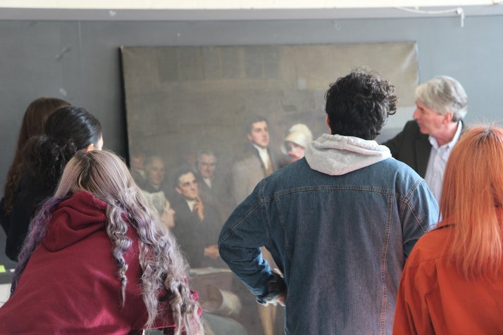 Students study a campus permanent collection painting in the midst of its conservation process.
