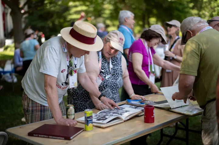 Alumni examine yearbook at table