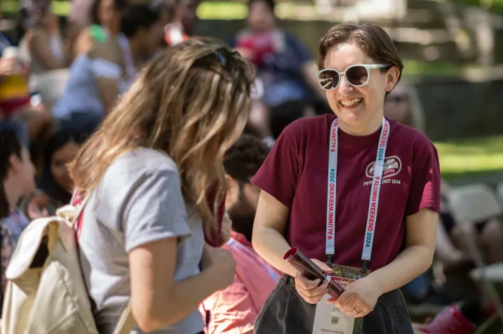 Alumni smile and laugh in conversation