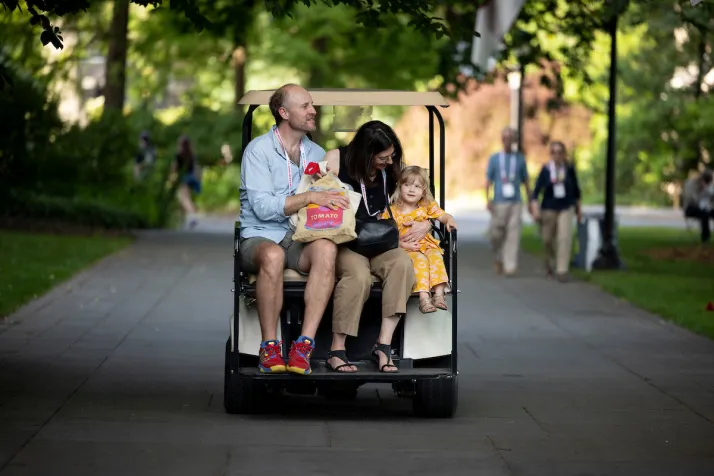 Family rides in golf cart going down Magill walk
