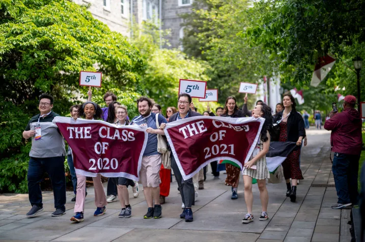 Alumni hold up banners at Parade of Classes