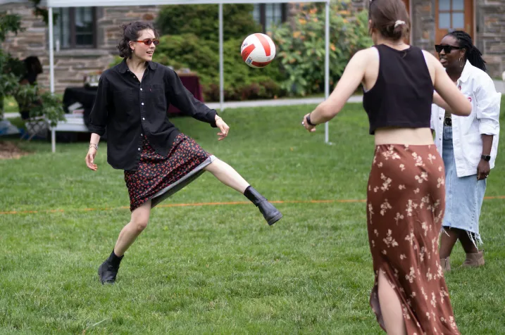 Person kicks soccer ball on lawn