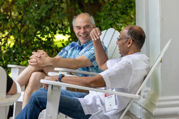 Alumni sitting on Adirondack chairs