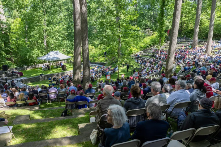 Alumni in outdoor amphitheater for collection on sunny day