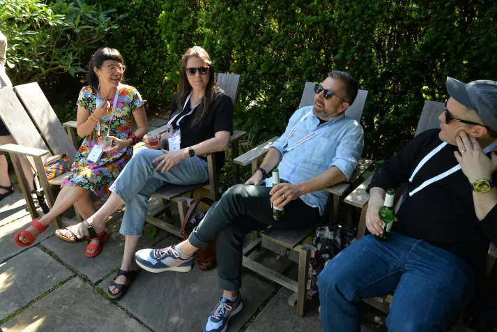 Group of alums sit on chairs outside