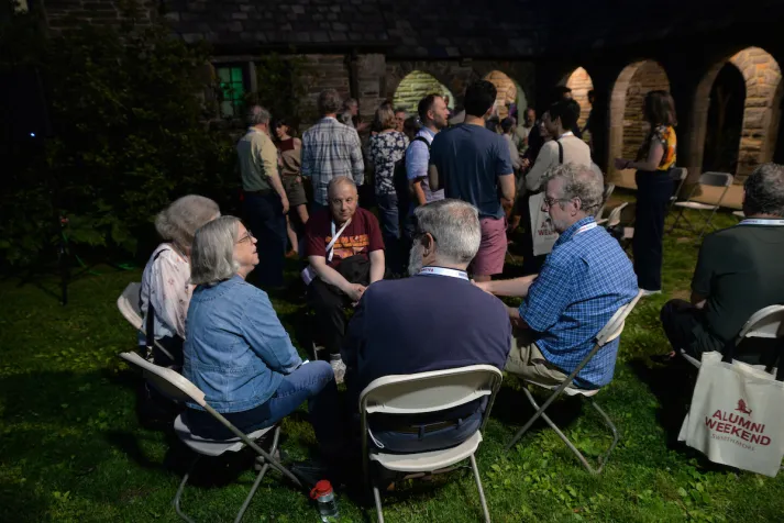 Alumni outside in circle during evening event