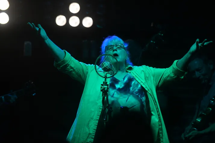 Woman sings on stage during evening event