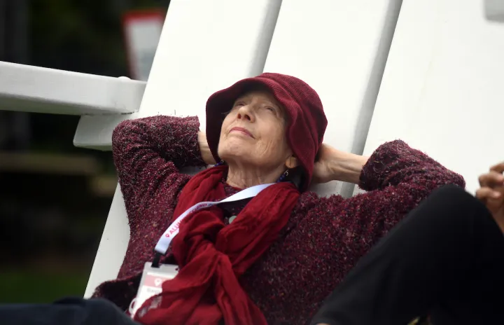 Person reclines on large white Adirondack chair