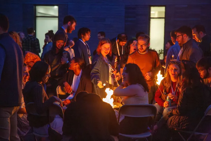 Alumni roast marshmallows during evening cookout 