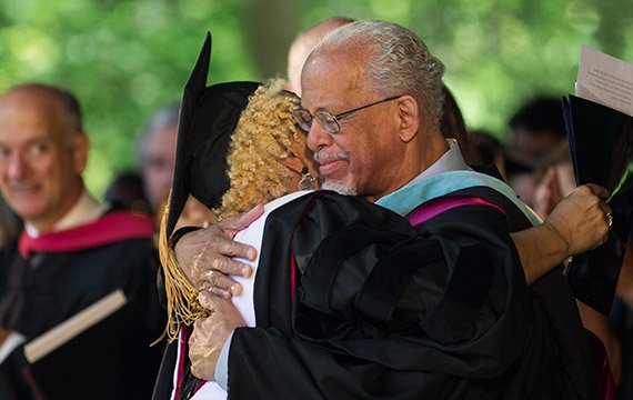Honorary degree recipient Vaneese Thomas '74 and Maurice Eldridge '61 embrace on stage at Commencement 2014