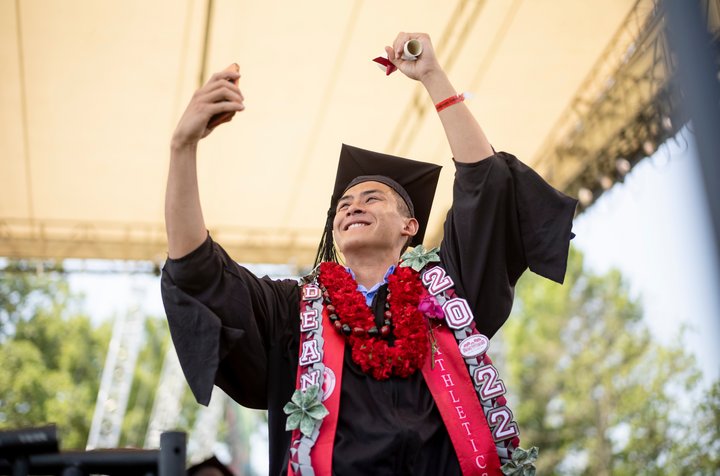 Student receives diploma and takes selfie