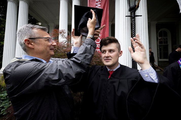 Parent helps student with graduation cap