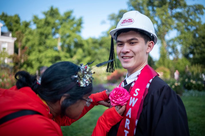 Student pins rose onto another student's sash