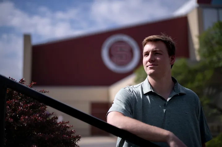 Michael Caprise outside building with Swarthmore "S" logo