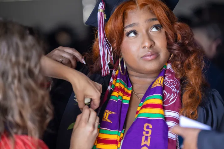 Student receives rose on commencement stole