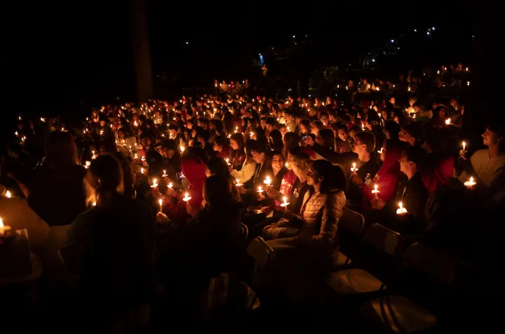 Students with candles in amphitheater at last collection
