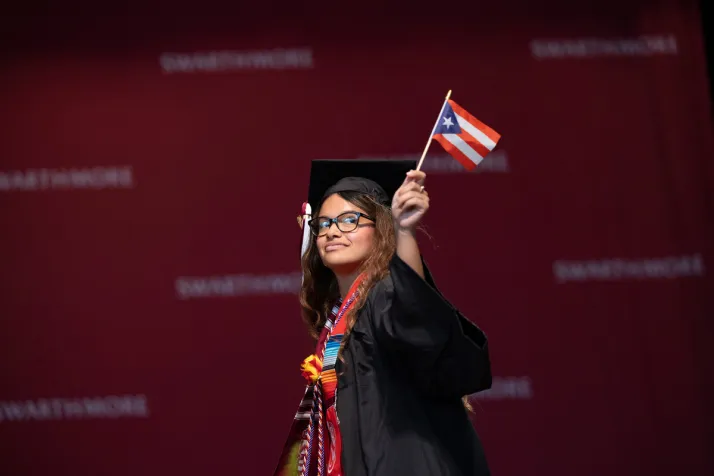 Student waves flag of Puerto Rico while crossing stage