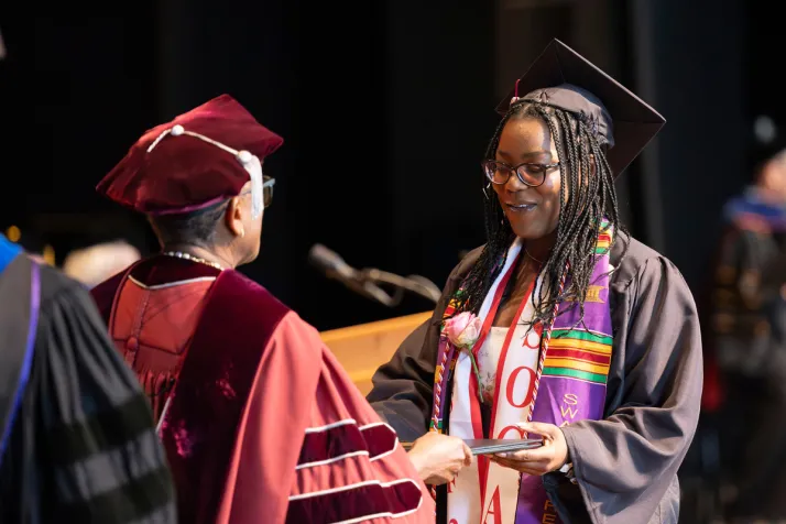 Student receives diploma from Val Smith