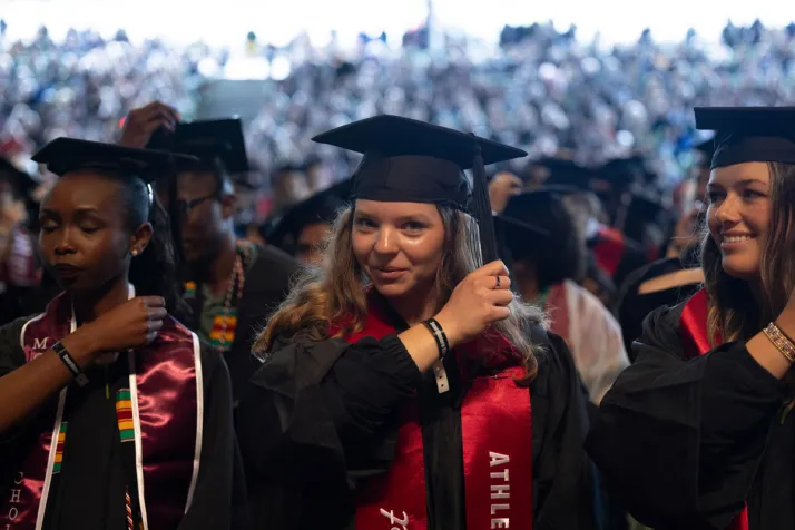 Students move tassels on graduation caps