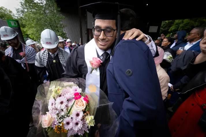 Student hugs family member after leaving commencement