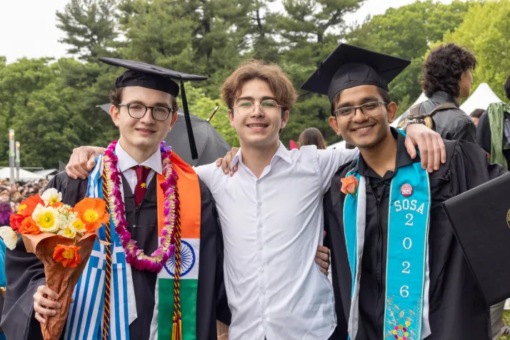Students pose with each other after graduation ceremony