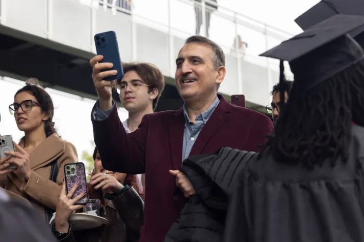 Parent takes photo on phone of grads