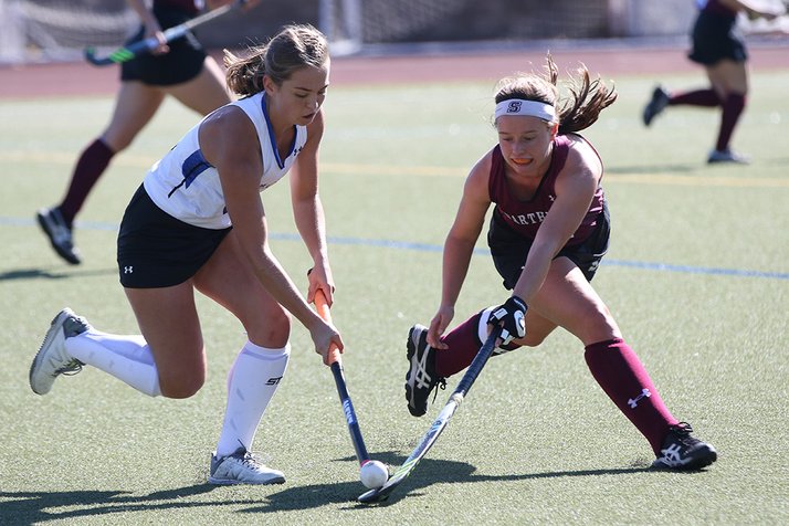Field hockey player fights for ball