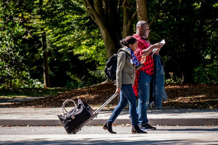 People with suitcases walk on Swarthmore's campus