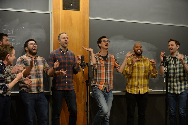 Group of men in plaid shirts sing in group