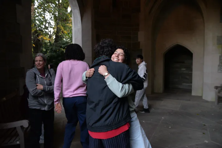 A capella singers hugging in Clothier Bell Tower