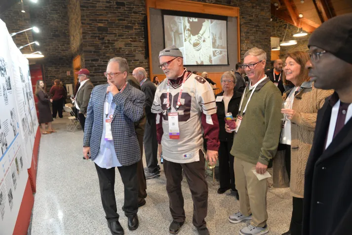Attendees look at poster for football team history