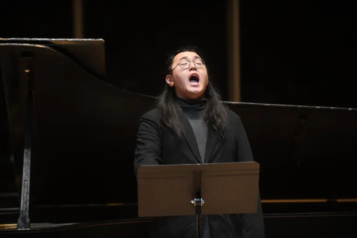 Close up of person in black shirt singing