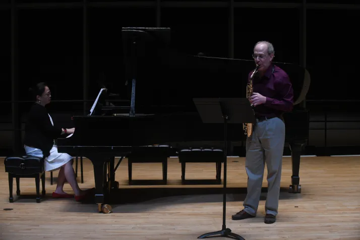 Person plays saxophone on stage