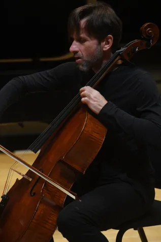 Close-up of person playing cello on stage