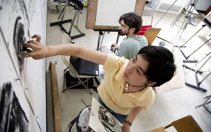 Student drawing with charcoal