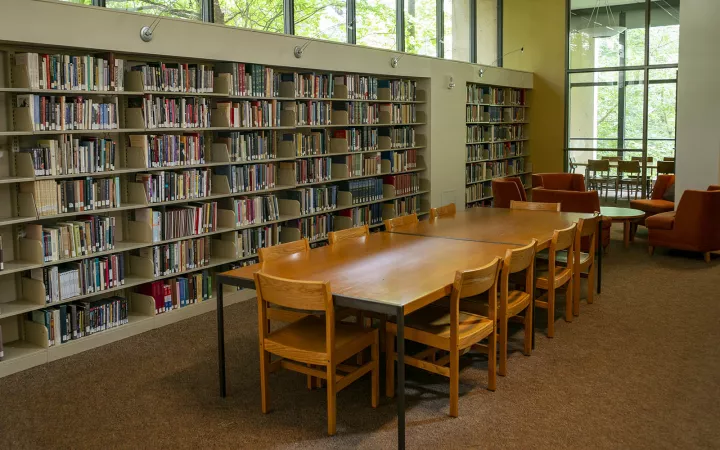 long table and chairs next to full bookshelves