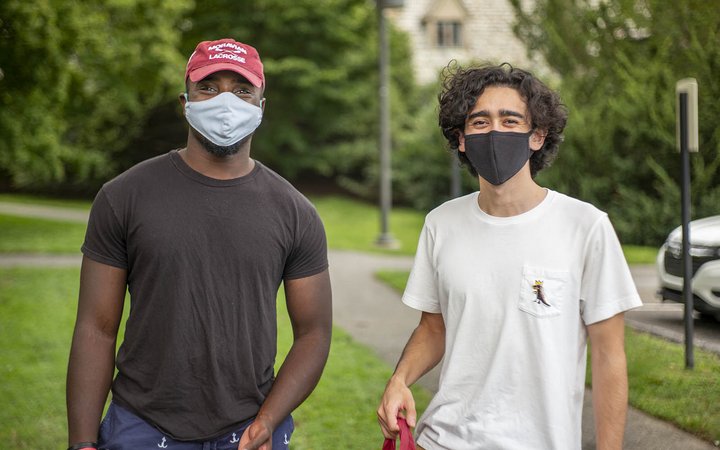 two students smiling under masks