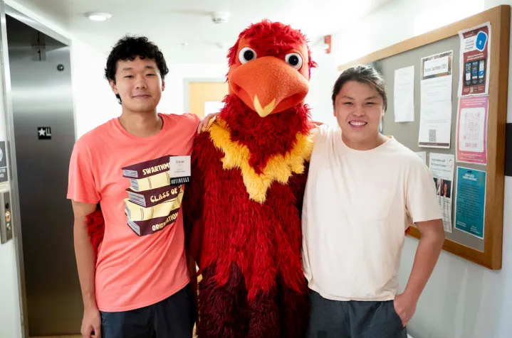 Two students pose with Phineas the Phoenix