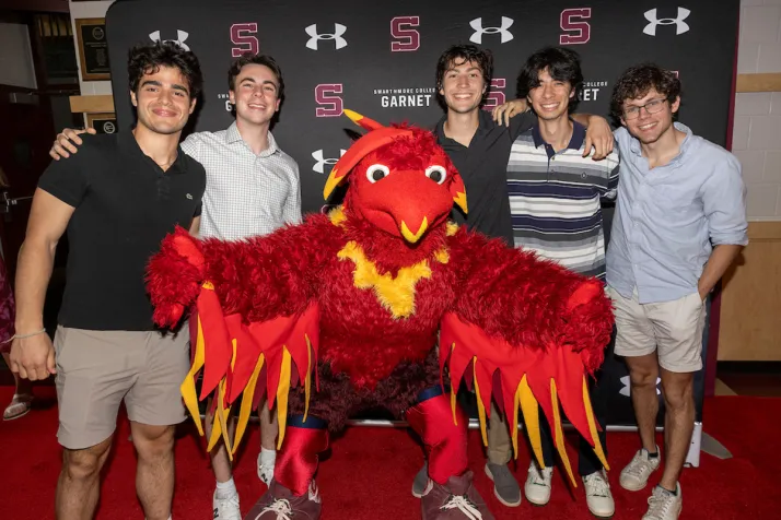 athletes pose with Phineas the phoenix