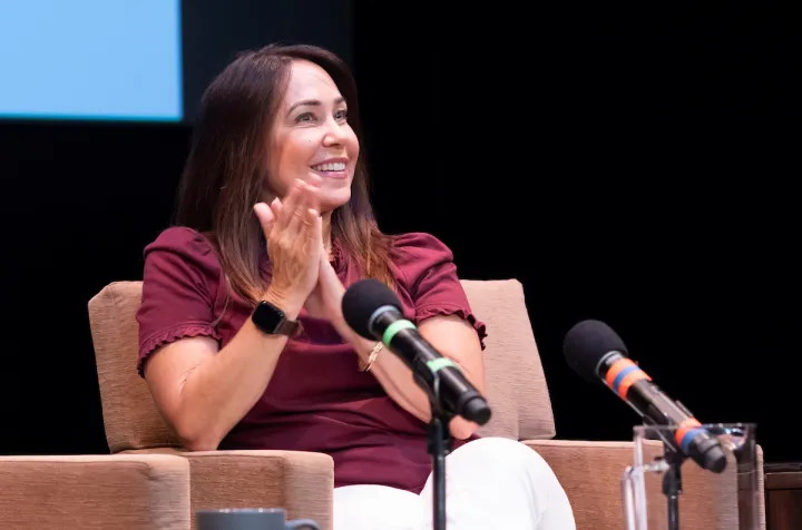 Stephanie Ives sits in chair with microphones in front