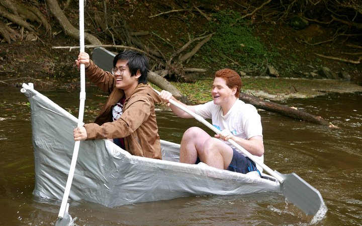 students paddling in the handmade boat