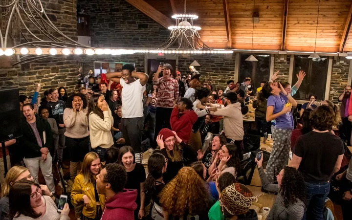 Students standing on tables in the dining hall