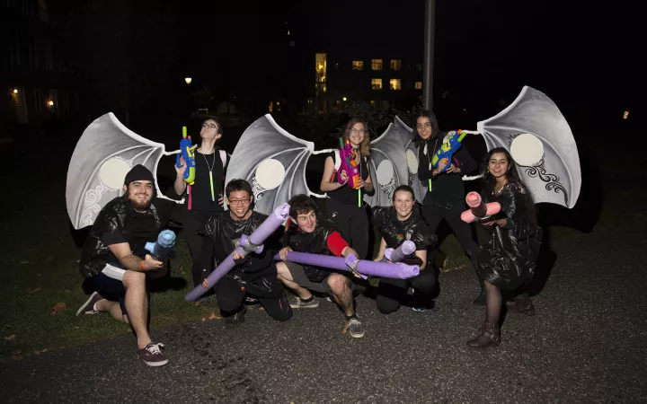 Student dressed in dark clothes and wings