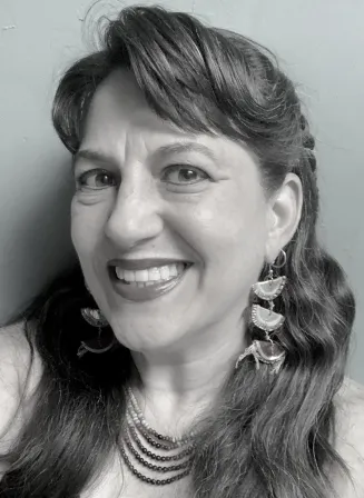 Headshot for a female presenting person with bangs and long hair, black and white image